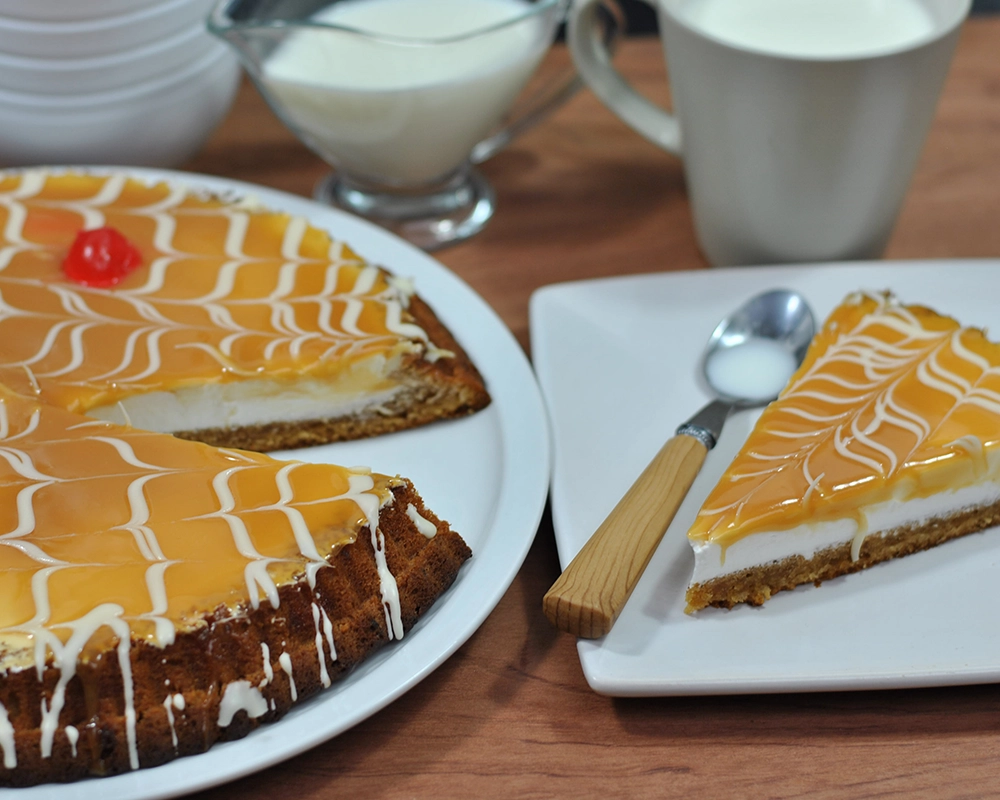 Tarta de dulce de leche entera y una porción servida en plato